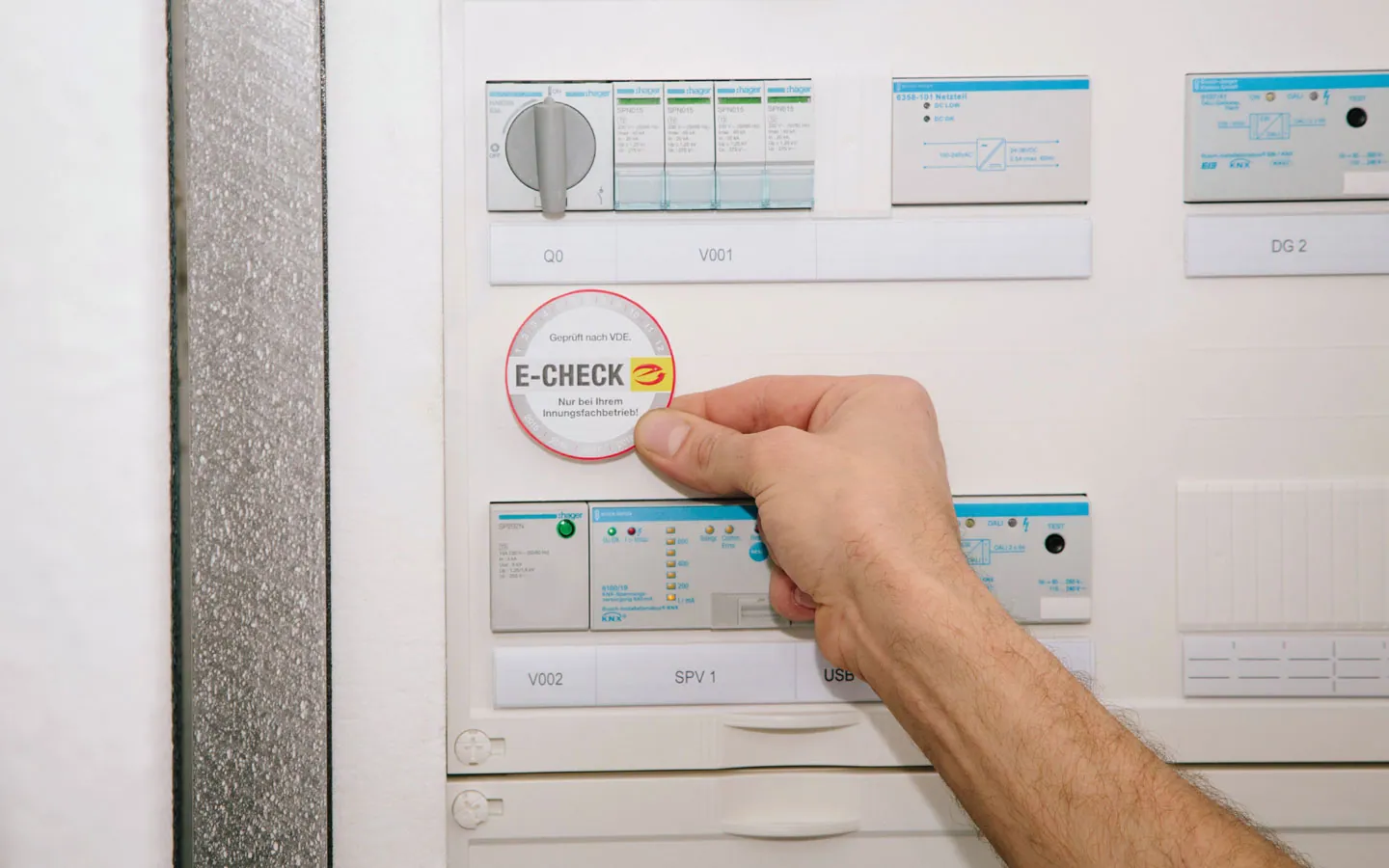 E-CHECK - Mitarbeiter klebt in der Verteilung die E-CHECK Plakette an &middot; Hornetz