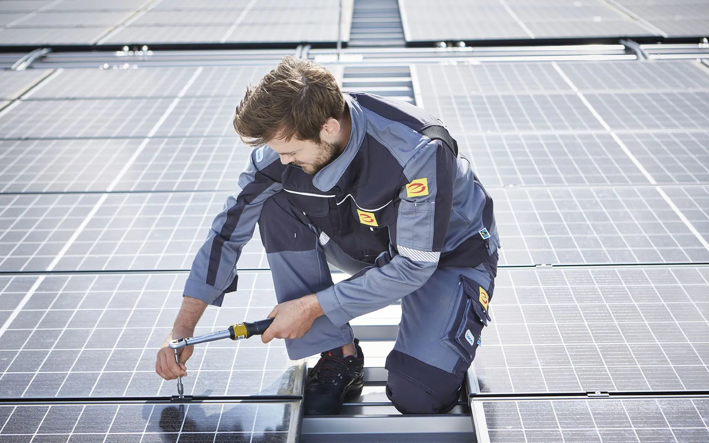 E-CHECK E-Mobilität - Mitarbeiter montiert auf dem Dach die neuen Solarmodule &middot; Hornetz